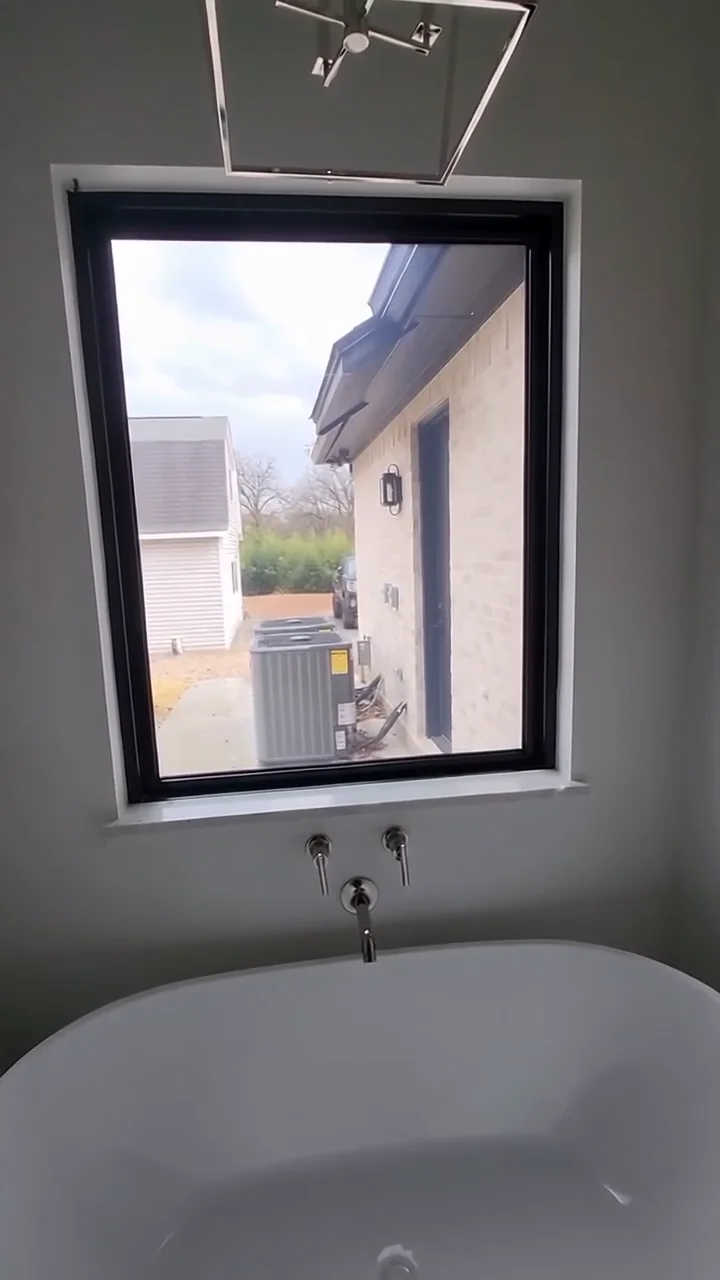 Bathroom window above a freestanding tub with Smart Film in clear mode