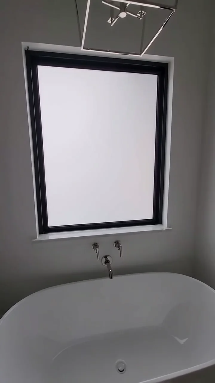 Bathroom window above a freestanding tub with Smart Film in privacy mode